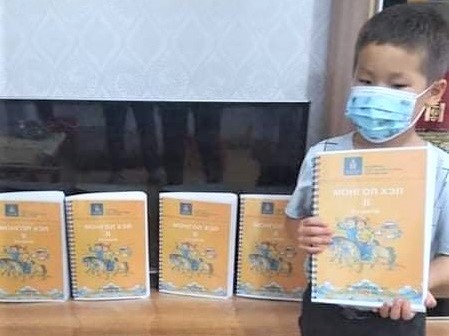 点字印刷された教科書を持つ児童